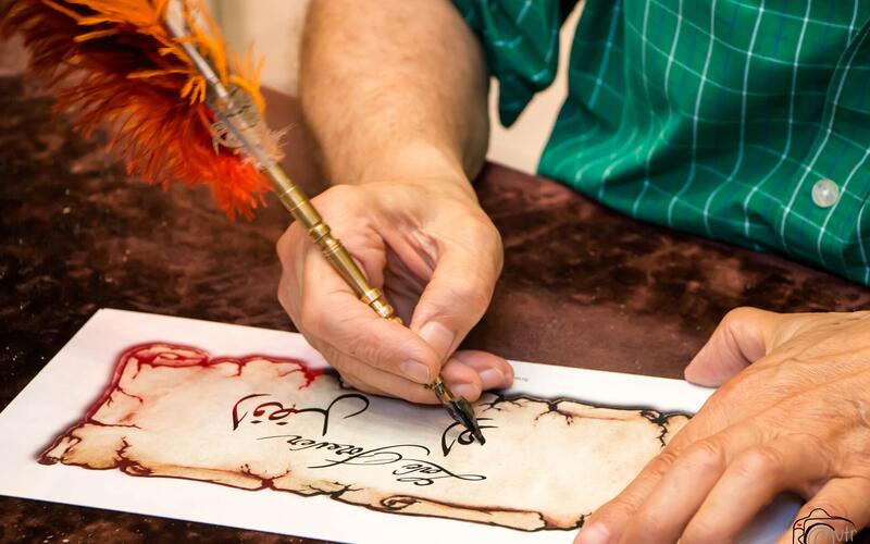 Een kalligraaf schrijft Arabische letters met een rietpen