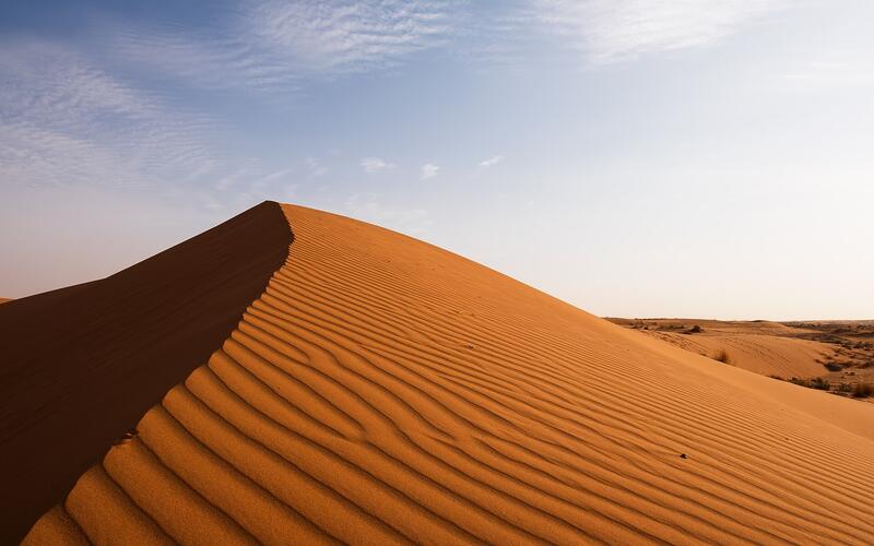 Een rode zandduin onder een blauwe lucht in Saoedi-Arabië
