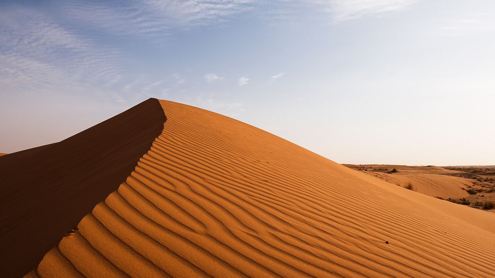 Een rode zandduin onder een blauwe lucht in Saoedi-Arabië