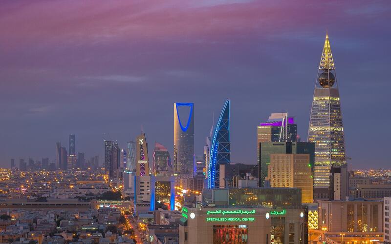 De verlichte skyline van Riyad bij avond met het financiële district KAFD